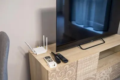 a flat screen tv on a wooden stand with remote controls at Cozy 1BR in Heart of Oborishte with Private Parking in Sofia