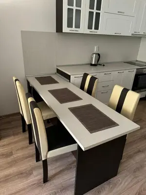 a kitchen with a table and chairs and white cabinets at Апартамент Клисура in Plovdiv