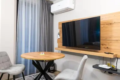 a room with a table and a tv on a wall at Apartmenthaus Oborishte - 27 in Panagyurishte