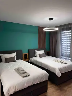 two beds in a room with green walls at Apartmenthaus Oborishte - 27 in Panagyurishte