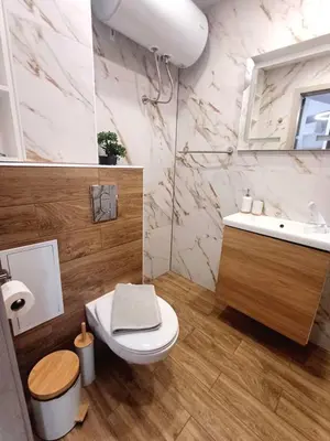 a bathroom with a toilet and a sink and a mirror at Apartmenthaus Oborishte - 27 in Panagyurishte