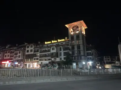 a large building with a clock tower at night at Bansko Royal Towers APARTMENT 738 in Bansko