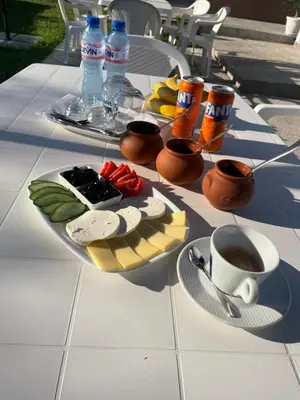 a table with a plate of food and a cup of coffee at Къща Цвети in Dobrinishte
