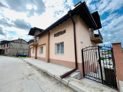 a building with a gate next to a street at Къща Цвети in Dobrinishte