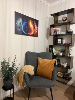 a living room with a chair and a book shelf at Elements Stylish Central 1BDR w High Speed WiFi and Work Space in Sofia