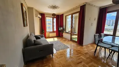 a living room with a couch and a table at Business Park Retreat: 1BR with Mountain View in Sofia