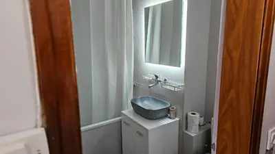 a small bathroom with a sink and a mirror at Business Park Retreat: 1BR with Mountain View in Sofia
