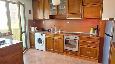 a kitchen with wooden cabinets and a washer and dryer at Business Park Retreat: 1BR with Mountain View in Sofia