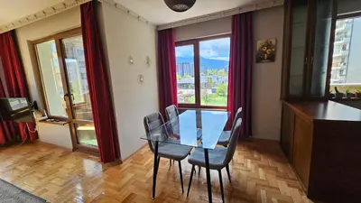 a dining room with a glass table and chairs at Business Park Retreat: 1BR with Mountain View in Sofia