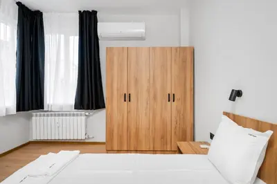 a bedroom with a bed and a wooden cabinet at Cozy Flats Near Alexander Nevski Cathedral by Flat Mаnager in Sofia