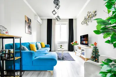 a living room with a blue couch and a christmas tree at 2BR Downtown Suit Next to Nevski Cathedral - AC in Sofia