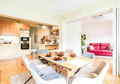 a kitchen and living room with a wooden table and chairs at Luxury And Spacious Apartment at the Hearth of the City in Sofia