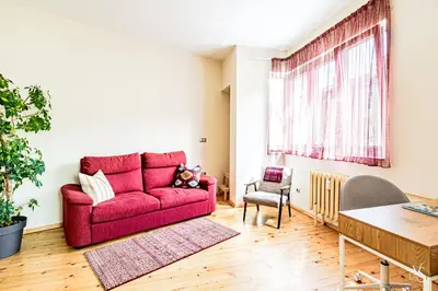 a red couch in a living room with a table at Luxury And Spacious Apartment at the Hearth of the City in Sofia