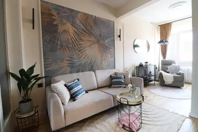 a living room with a couch and a painting on the wall at NEW The Blue Heart Of Sofia Center in Sofia