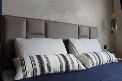 a bed with white pillows and a headboard at NEW The Blue Heart Of Sofia Center in Sofia