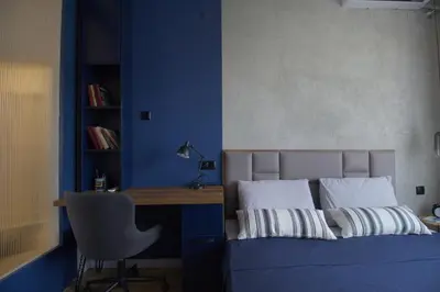 a bedroom with a bed and a desk with a chair at NEW The Blue Heart Of Sofia Center in Sofia