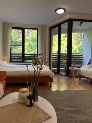 a bedroom with a bed and a table with flowers on it at Николай Желев-Първи ЕООД in Pamporovo