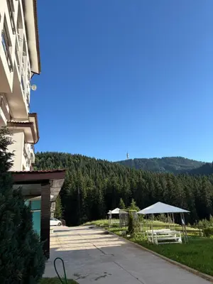 a view of a building with a table and chairs at Николай Желев-Първи ЕООД in Pamporovo