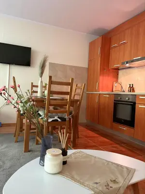 a living room with a table and a kitchen at Николай Желев-Първи ЕООД in Pamporovo