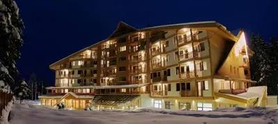 a large building in the snow at night at Студио в Хотел Айсберг in Borovets