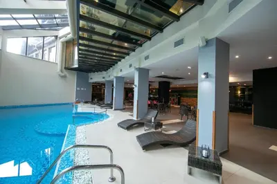 a large swimming pool with chairs in a building at Студио в Хотел Айсберг in Borovets
