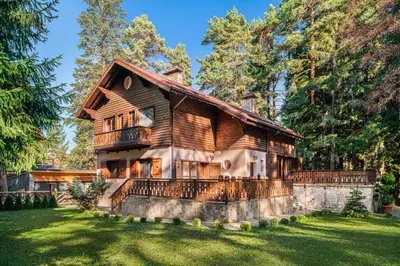 a log home with a balcony on a lawn at Mountain Villa Borovets in Borovets
