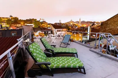 a balcony with chairs and tables on a roof at Residence Art Guest House in Plovdiv