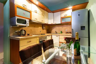 a kitchen with a glass table with a bottle of wine at Residence Art Guest House in Plovdiv