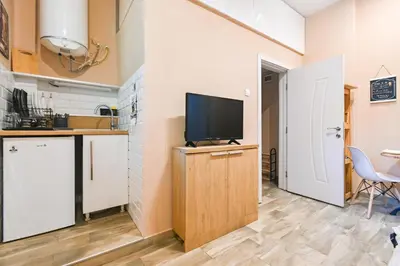 a kitchen with a tv on a cabinet with a table at Central 47 in Sofia