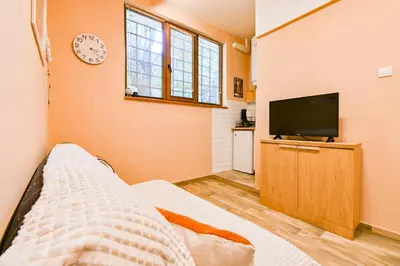 a bedroom with a bed and a tv on a wall at Central 47 in Sofia