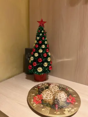 a christmas tree next to a plate with a christmas ornament at 2-bedroom, 2-bathroom with fireplace and garden at Winslow Infinity in Bansko