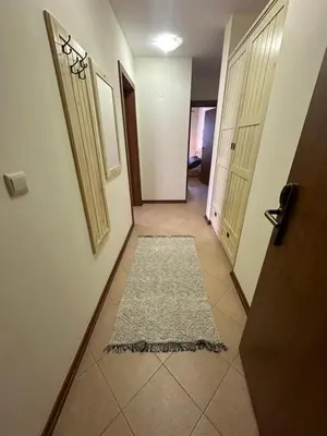 a hallway with a door and a rug on the floor at Pirin Golf Mountain View Apartment in Razlog
