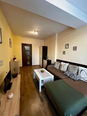 a living room with a couch and a table at Cute and Cozy Flat in Sofia