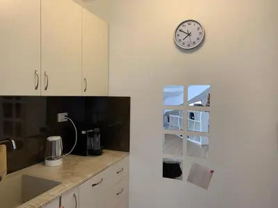 a kitchen with white cabinets and a clock on the wall at Mountain View in Razlog