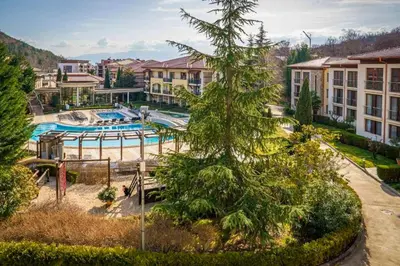 an apartment complex with a swimming pool and a tree at Апартамент Пирин Apartment Pirin in Sandanski