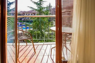 a balcony with a chair and a view of a pool at Апартамент Пирин Apartment Pirin in Sandanski