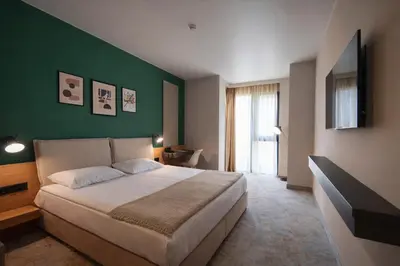 a bedroom with a large bed and a green wall at B1 Downtown Hotel, Sofia in Sofia