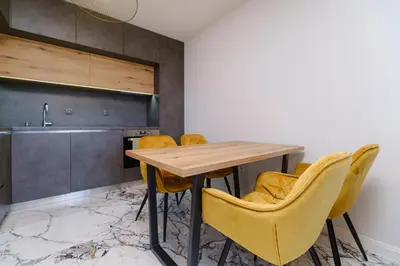 a kitchen with a wooden table and yellow chairs at Lauta Forest 1-bedroom apartment in Plovdiv
