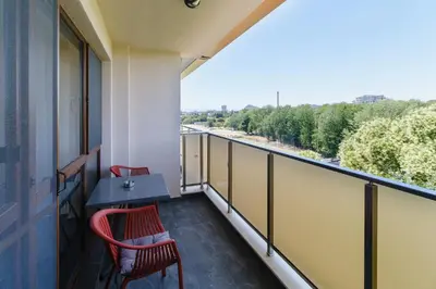 a balcony with a table and chairs and a view at Lauta Forest 1-bedroom apartment in Plovdiv