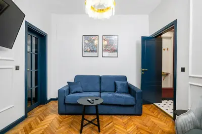 a living room with a blue couch and a table at Royal Retreat - Your central designer spot by Flat Mаnager in Sofia