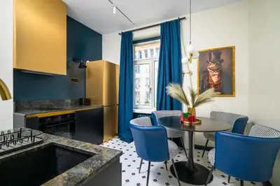 a kitchen with blue chairs and a table with a tableablish at Royal Retreat - Your central designer spot by Flat Mаnager in Sofia
