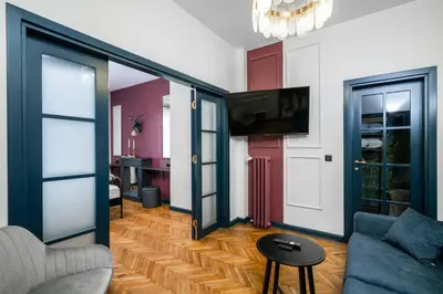 a living room with a couch and a tv at Royal Retreat - Your central designer spot by Flat Mаnager in Sofia