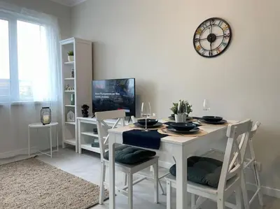 a dining room with a table and a clock on the wall at Borisova Garden Skyline by Cosher in Sofia