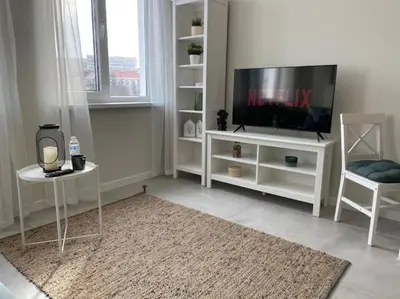 a living room with a flat screen tv on a white entertainment center at Borisova Garden Skyline by Cosher in Sofia