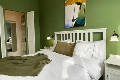 a bedroom with a large white bed with green walls at Borisova Garden Skyline by Cosher in Sofia