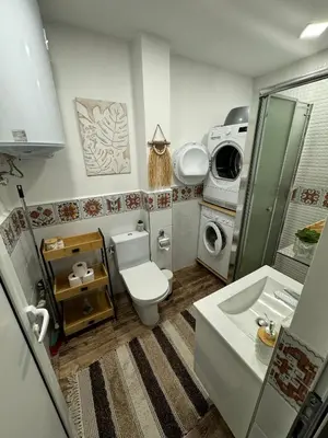 a bathroom with a toilet and a washing machine at Boho Apartment Plovdiv with Private Parking Space in Plovdiv
