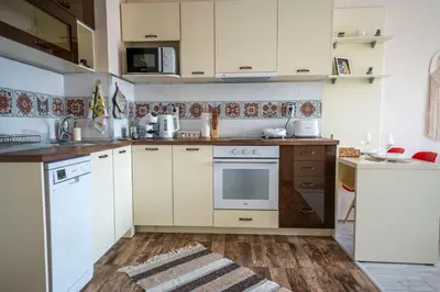 a kitchen with white appliances and a wooden floor at Boho Apartment Plovdiv with Private Parking Space in Plovdiv