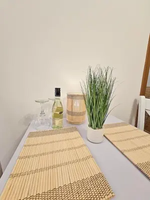 a table with two wooden mats and a bottle of wine at Cozy Studio in Semiramida Gardens - Borovets Hills 39 in Borovets