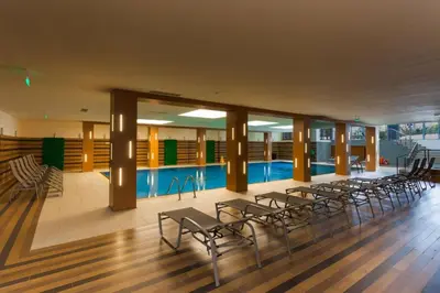 a swimming pool with a bunch of chairs in a building at Cozy Studio in Semiramida Gardens - Borovets Hills 39 in Borovets