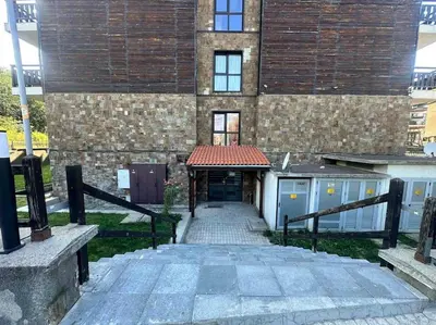 a building with a walkway leading to a garage at Pirin Sky in Bansko